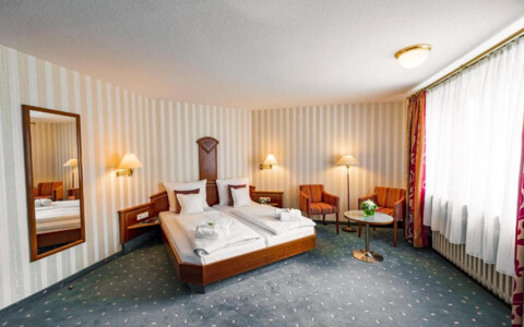 Gemütliches Hotelzimmer mit großem Bett, Nachttischen, Schreibtisch, Flachbildfernseher und viel Tageslicht  - Hotel Wartburg in Stuttgart
