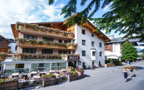 Fassade des Hotel Diana in Seefeld, umgeben von alpiner Landschaft und grünen Wiesen