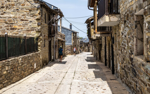 Enge, gepflasterte Gasse im Dorf El Acebo de San Miguel, gesäumt von traditionellen Steinhäusern