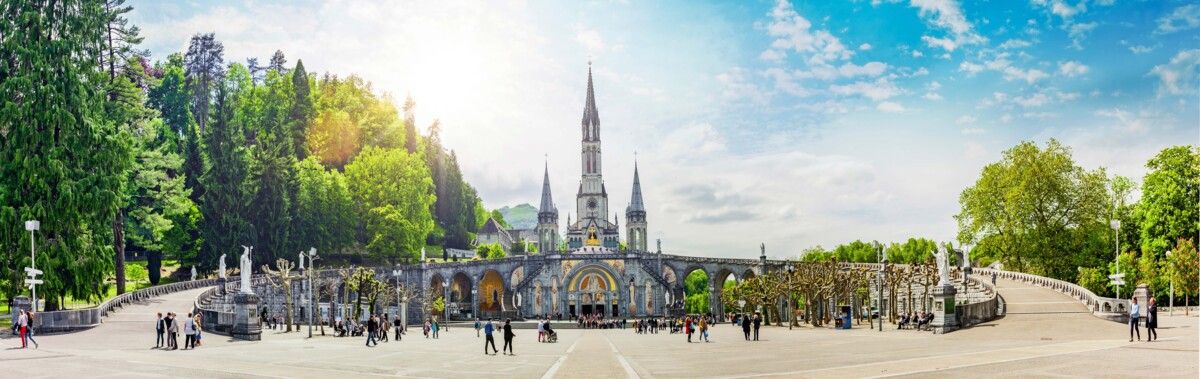 Der heilige Wallfahrtsort Lourdes in Frankreich, mit der berühmten Basilika und den Pilgern, die zur Grotte kommen