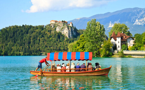 Traditionelles Pletna-Boot auf dem Bleder See, mit einem Bootsfahrer, der die Besucher zur Insel transportiert.