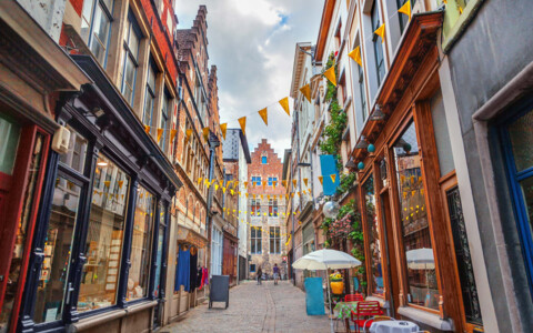 Malerische Gasse in Gent, Belgien, gesäumt von historischen Gebäuden und charmanten Geschäften