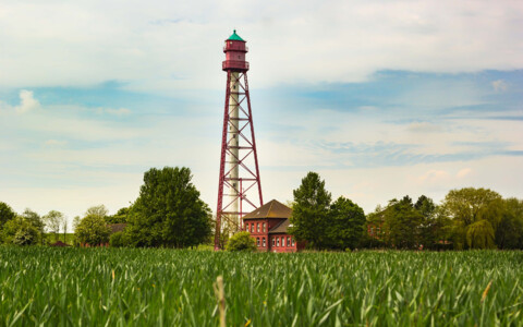 Der Leuchtturm von Campen an der Nordseeküste, ein markantes Wahrzeichen mit rotem Streifenmuster, das über das Wattenmeer wacht.