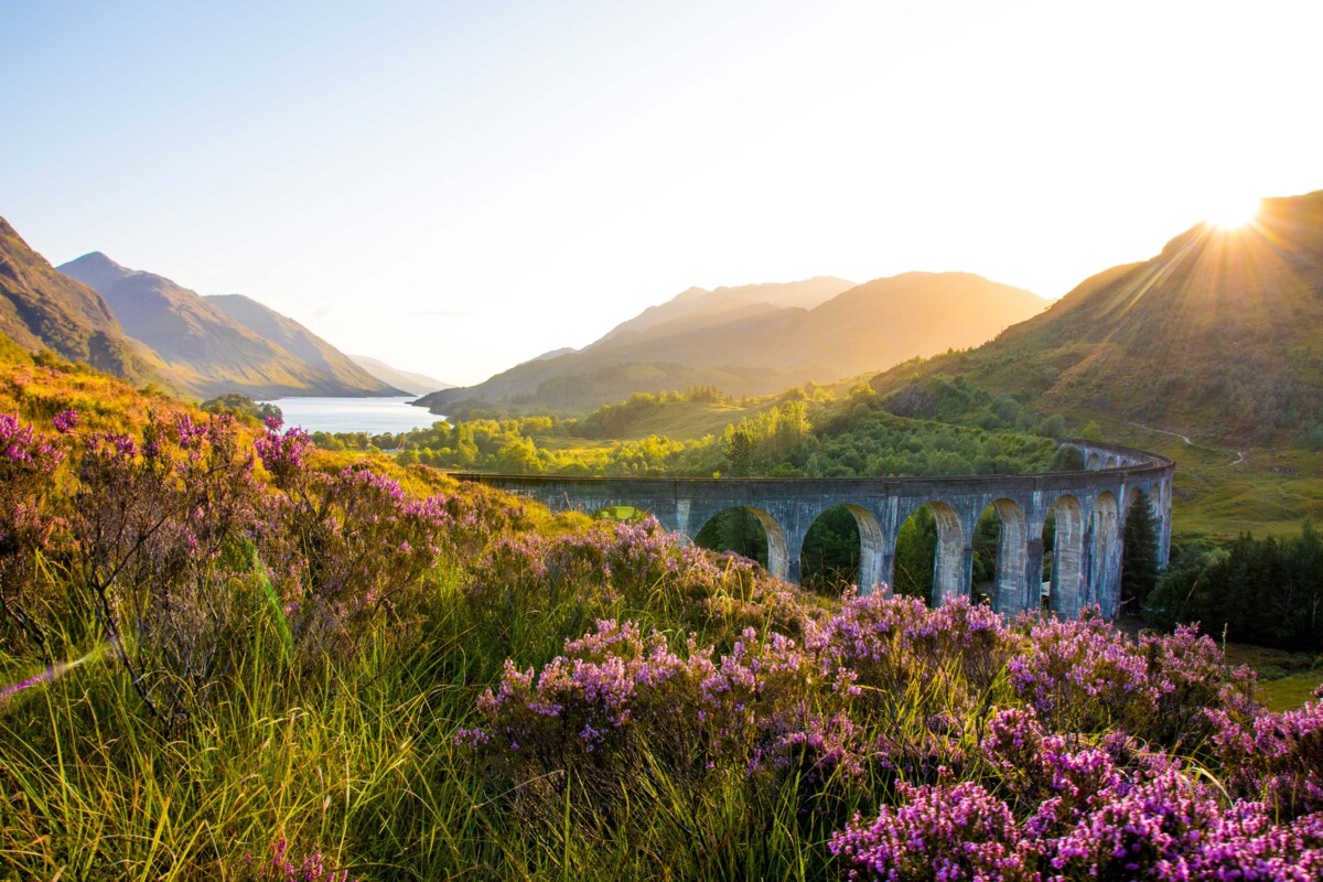 Das beeindruckende Glenfinnan Viadukt in den schottischen Highlands, bekannt durch die Harry-Potter-Filme, das majestätisch über die Landschaft spannt.