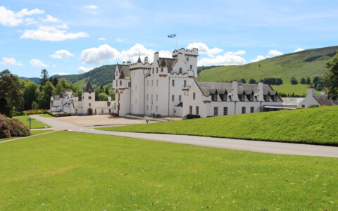 Das beeindruckende Blair Castle in Schottland, ein historisches weißes Schloss mit markanter Architektur, umgeben von weitläufigen Gärten und malerischer Landschaft.