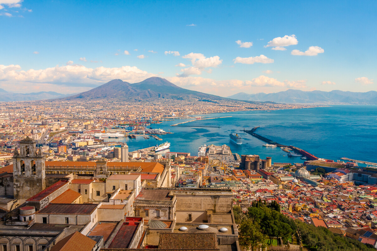 Die Stadt Neapel mit dem majestätischen Vesuv im Hintergrund, der über die Bucht von Neapel wacht, ein eindrucksvolles Bild der italienischen Küstenlandschaft.