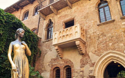 Der berühmte Balkon der Julia in Verona, umgeben von alten Backsteinmauern und einer romantischen Atmosphäre. Der Balkon gilt als Symbol für Shakespeares „Romeo und Julia“.