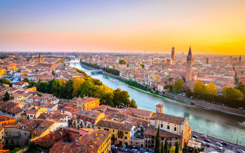 Atemberaubender Panoramablick über die Stadt Verona, mit ihren antiken Gebäuden, Brücken über die Etsch und der mittelalterlichen Stadtmauer. Die Berge sind in der Ferne sichtbar.