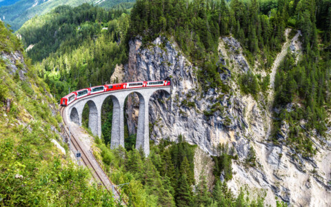 Der Glacier Express überquert das imposante Landwasserviadukt, ein Meisterwerk der Ingenieurskunst, eingebettet in die dramatische Alpenlandschaft.