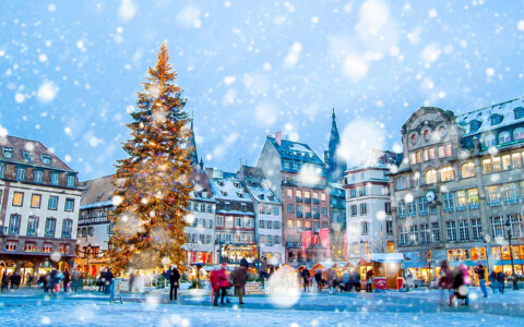 Traditioneller Weihnachtsmarkt in Straßburg, Frankreich, mit prächtigen Dekorationen und einem imposanten Weihnachtsbaum auf dem Platz